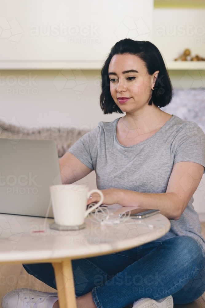 Image of woman using laptop at home - Austockphoto