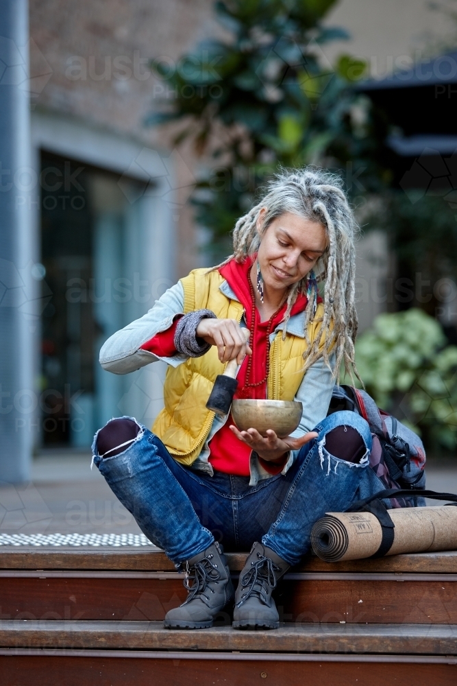 Woman using Tibetan singing bowl - Australian Stock Image