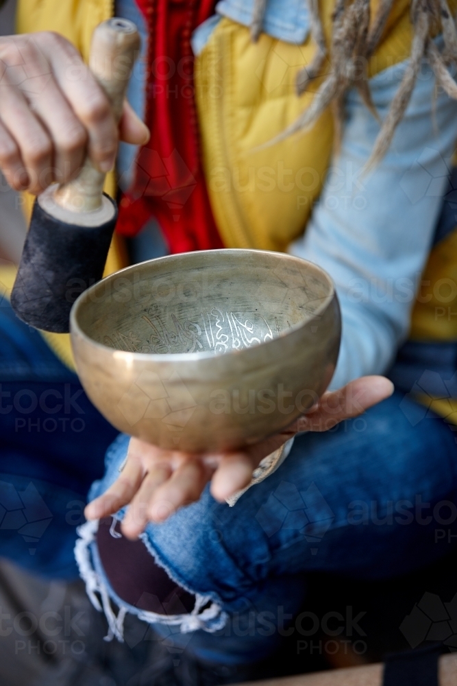 Woman using Tibetan singing bowl - Australian Stock Image