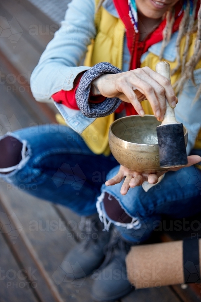 Woman using Tibetan singing bowl - Australian Stock Image