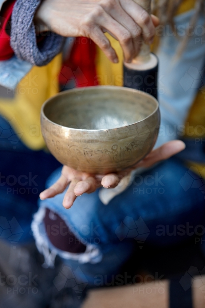 Woman using Tibetan singing bowl - Australian Stock Image