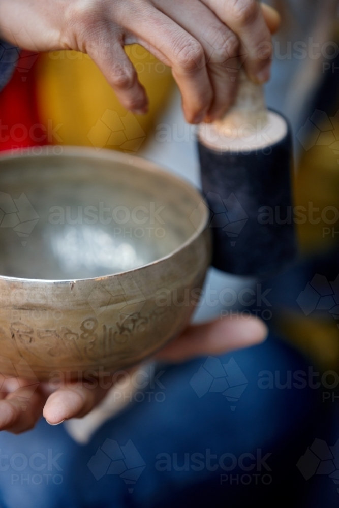 Woman using Tibetan singing bowl - Australian Stock Image