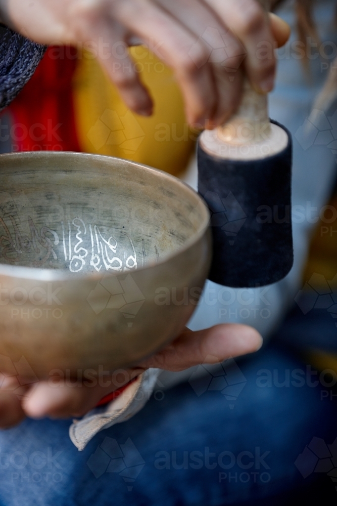 woman using Tibetan singing bowl - Australian Stock Image