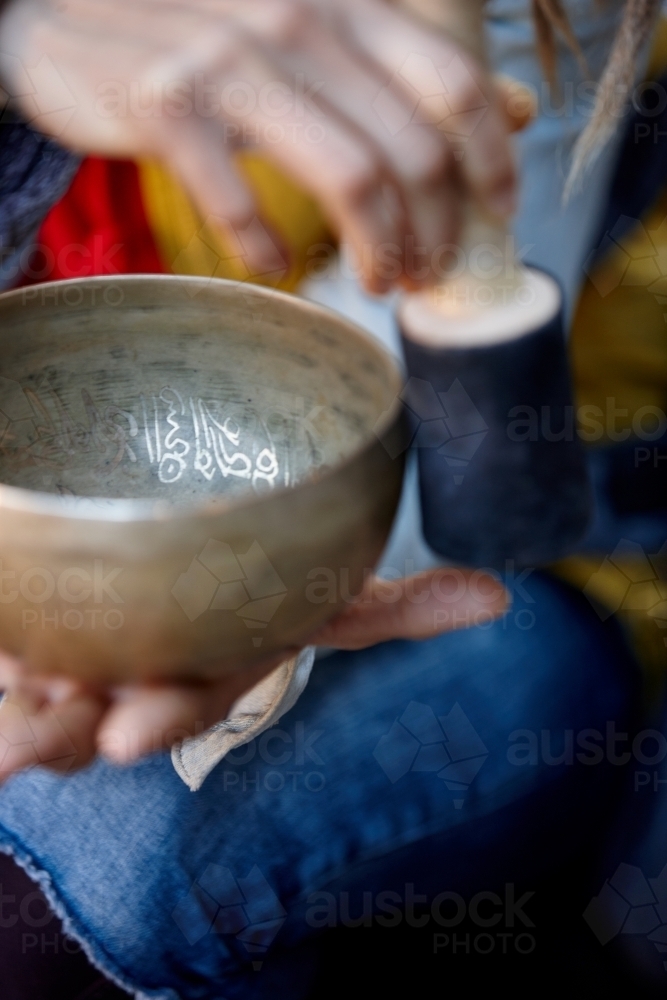 Woman using Tibetan singing bowl - Australian Stock Image