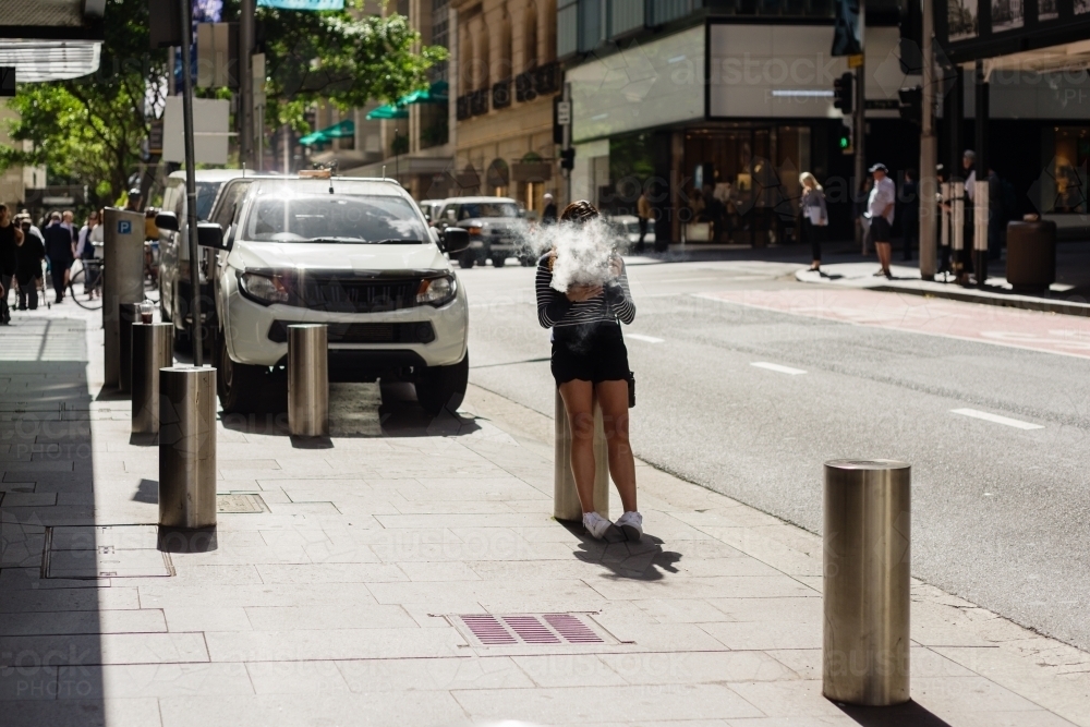 woman vaping in the street - Australian Stock Image