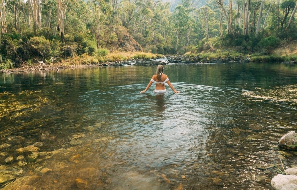 Woman wading in thermal springs in the Apline region Australia - Australian Stock Image