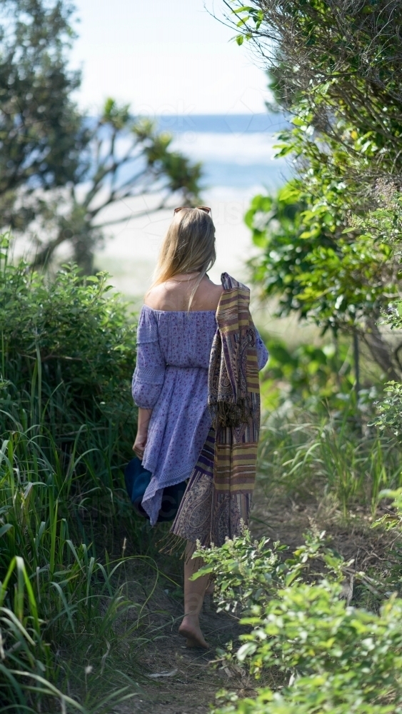 Woman walking away through beach path - Australian Stock Image