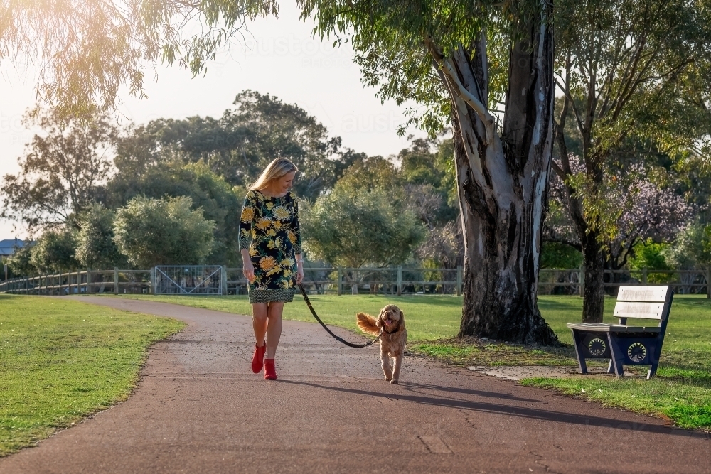 Woman walking dog in a park - Australian Stock Image