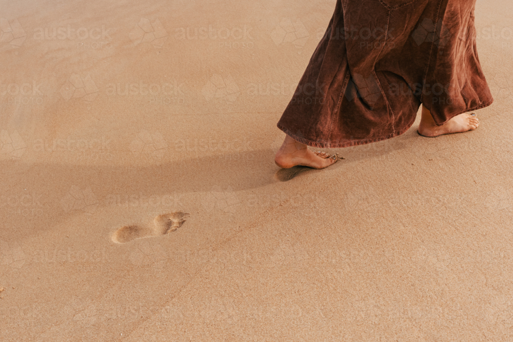 woman walking in sand leaving footprint - Australian Stock Image