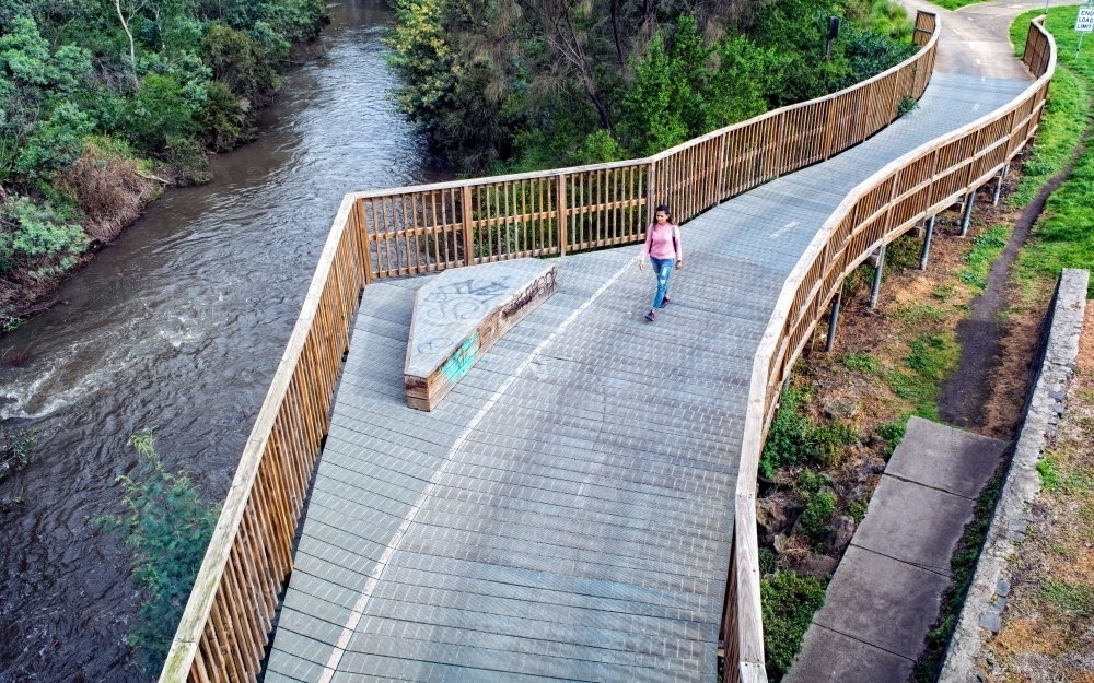 Woman walking on a bridge along the Merri Creek Trail - Australian Stock Image