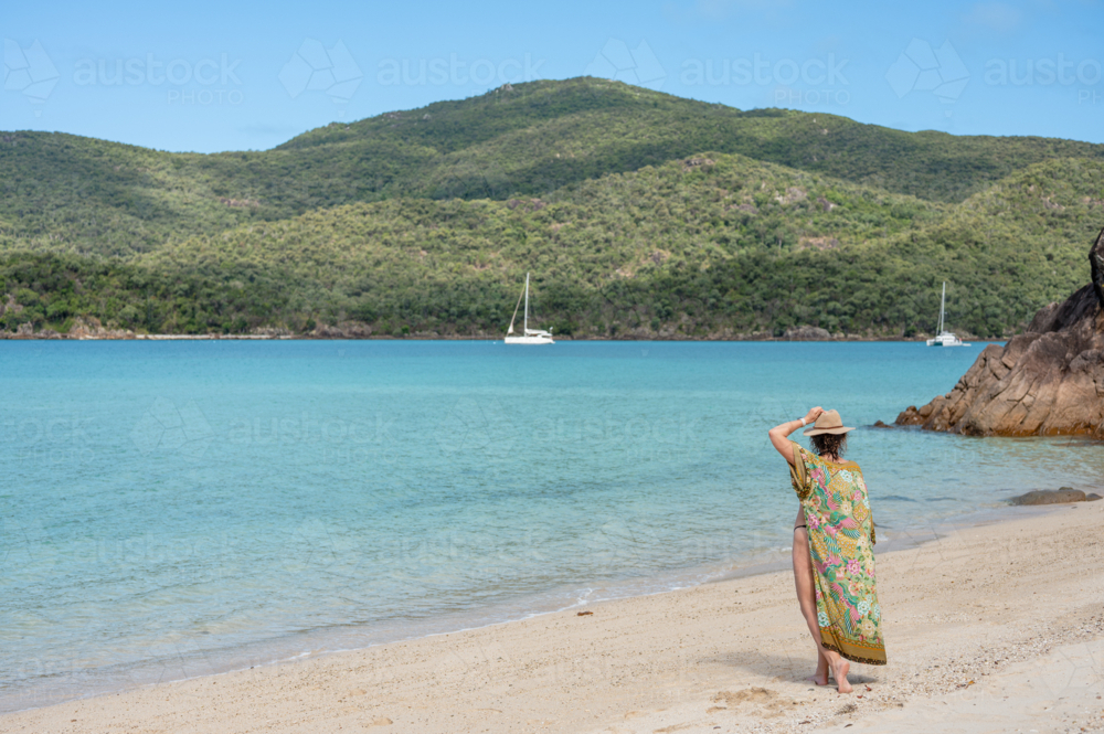 woman walking on white sand beach - Australian Stock Image