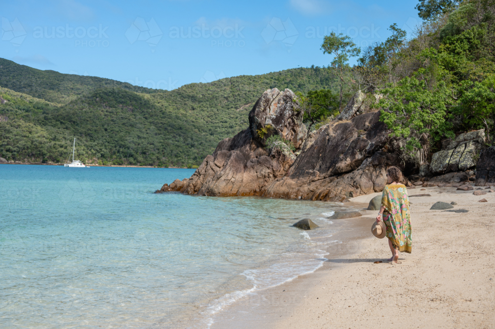 woman walking on white sand beach - Australian Stock Image