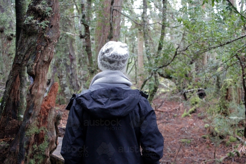 Woman walking through bush wearing beanie and jacket - Australian Stock Image