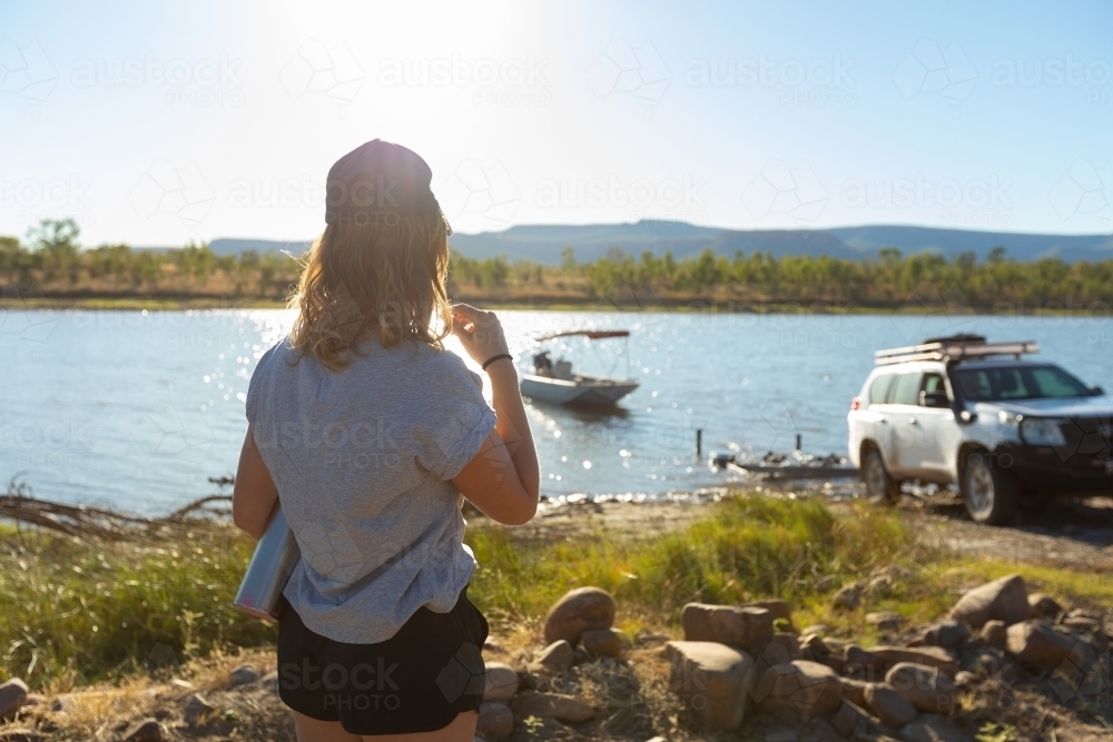 Woman watching others drive a boat onto boat trailer - Australian Stock Image