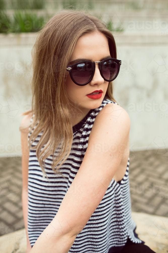Woman wearing a striped top and sunglasses - Australian Stock Image