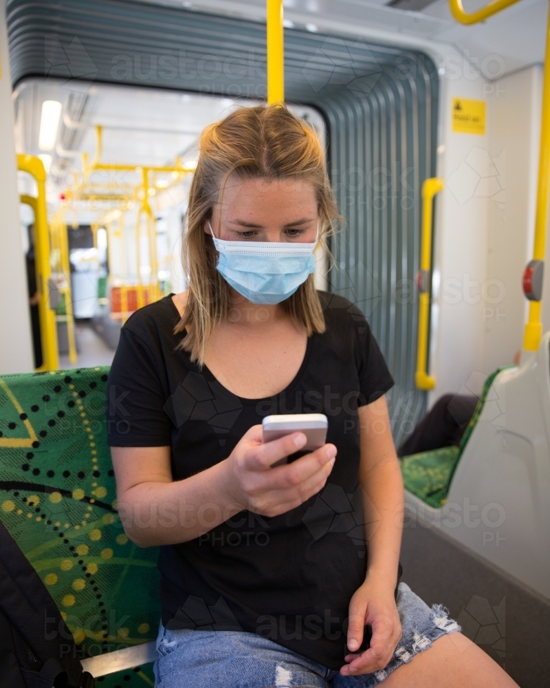 Woman Wearing Face Mask Travelling on Tram - Australian Stock Image