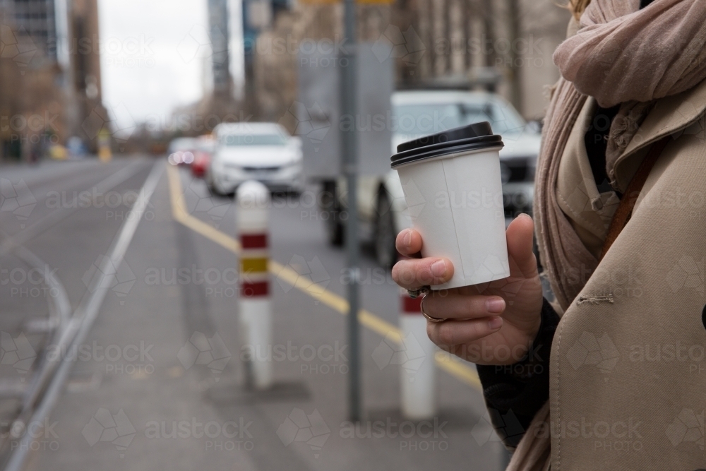 Woman with Coffee Waiting for Tram : Austockphoto Woman with Coffee Waiting for Tram - Australian Stock Image