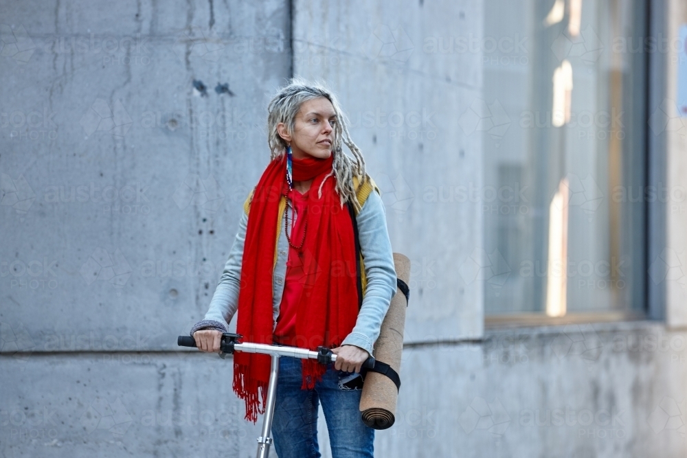 Woman with dreadlocks and scooter in city - Australian Stock Image