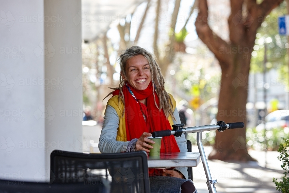Woman with dreadlocks and scooter in city - Australian Stock Image