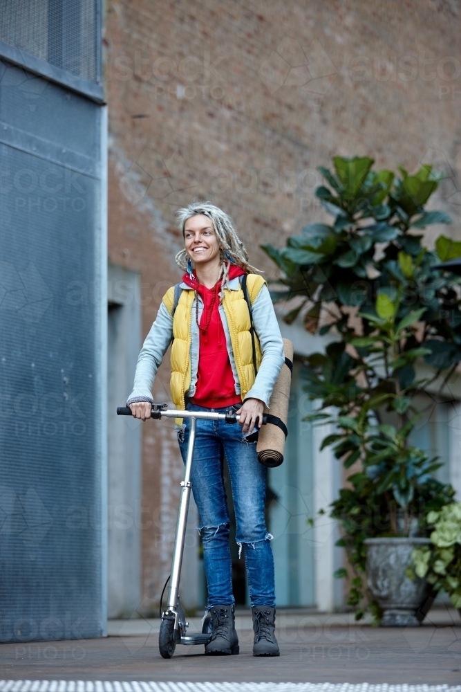 Woman with dreadlocks and scooter in city - Australian Stock Image