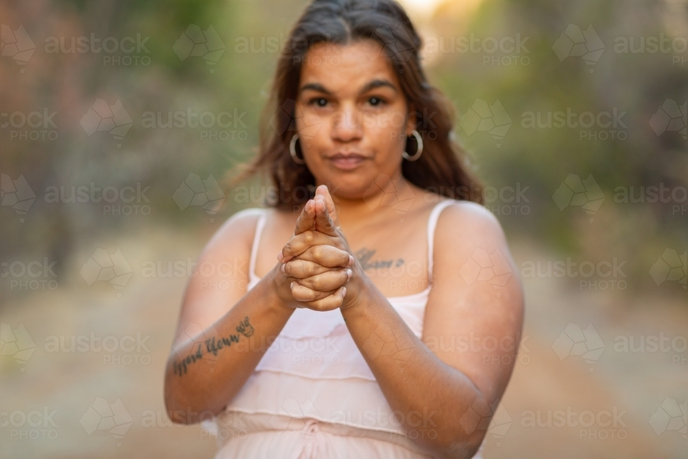 woman with hands clasped and index fingers pointing forward - Australian Stock Image