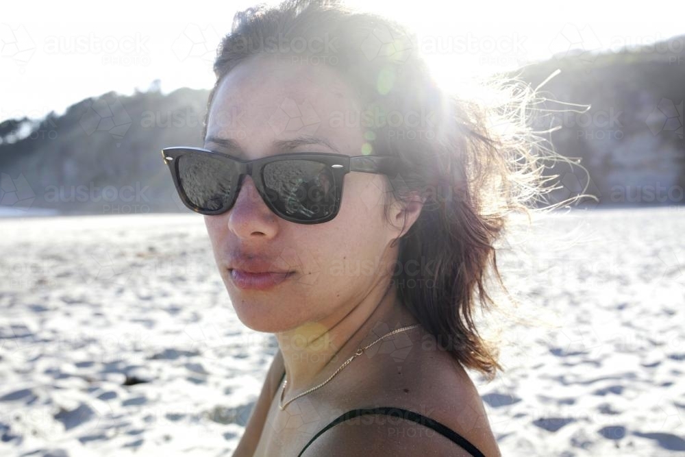 Woman with sunglasses on at beach - Australian Stock Image
