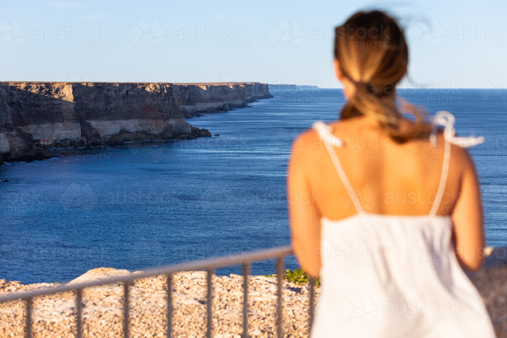 Woman with view of Nullarbor cliffs and ocean on the Great Australian Bight - Australian Stock Image