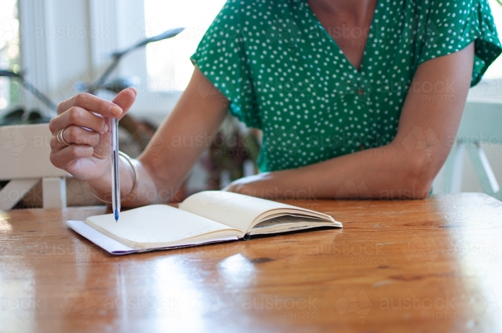Woman writing in journal - Australian Stock Image