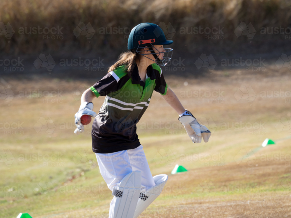 Women's cricket female wicket keeper catching the ball on the field - Australian Stock Image