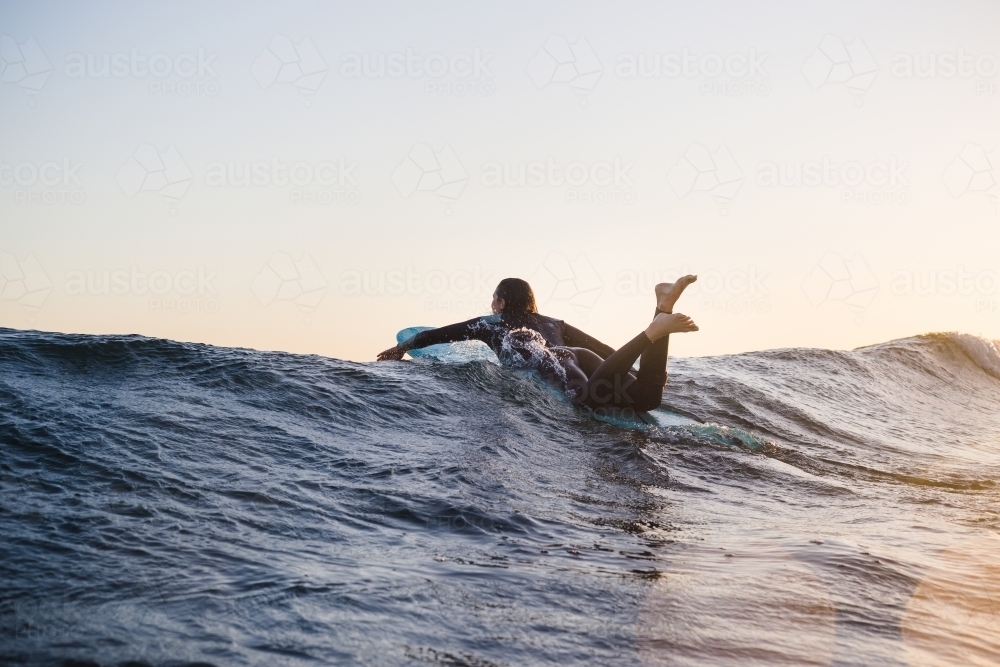 Women surfing over wave at sunset Phillip Island - Australian Stock Image