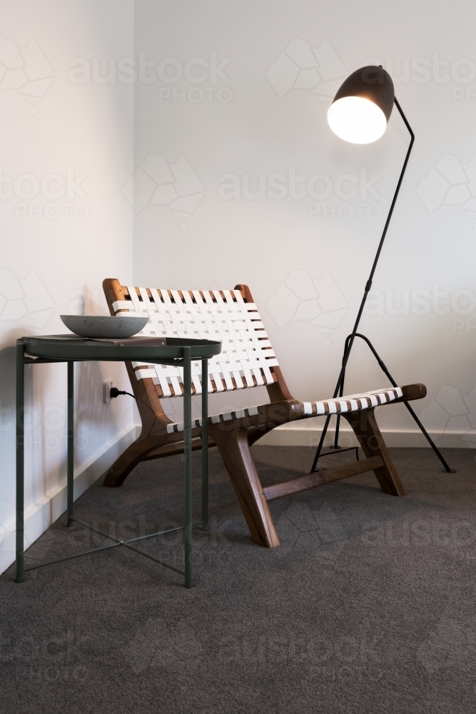 Wood and woven occasional chair with floor lamp and side table - Australian Stock Image