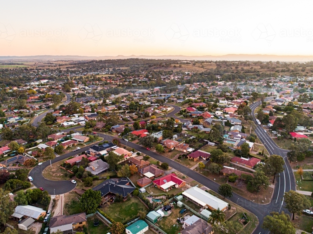 Wood smoke collecting over houses in town at dusk - Australian Stock Image