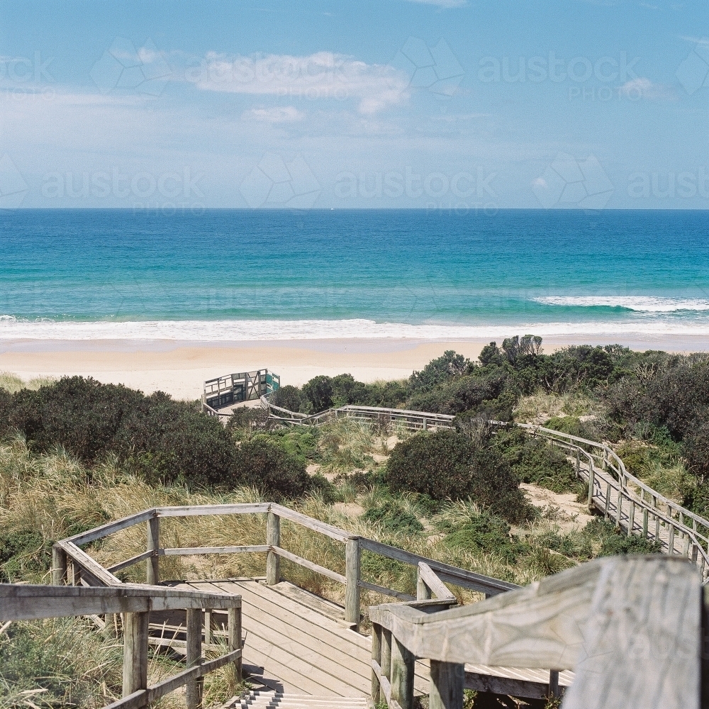 Wooden boardwalk leading down to a deserted beach - Australian Stock Image