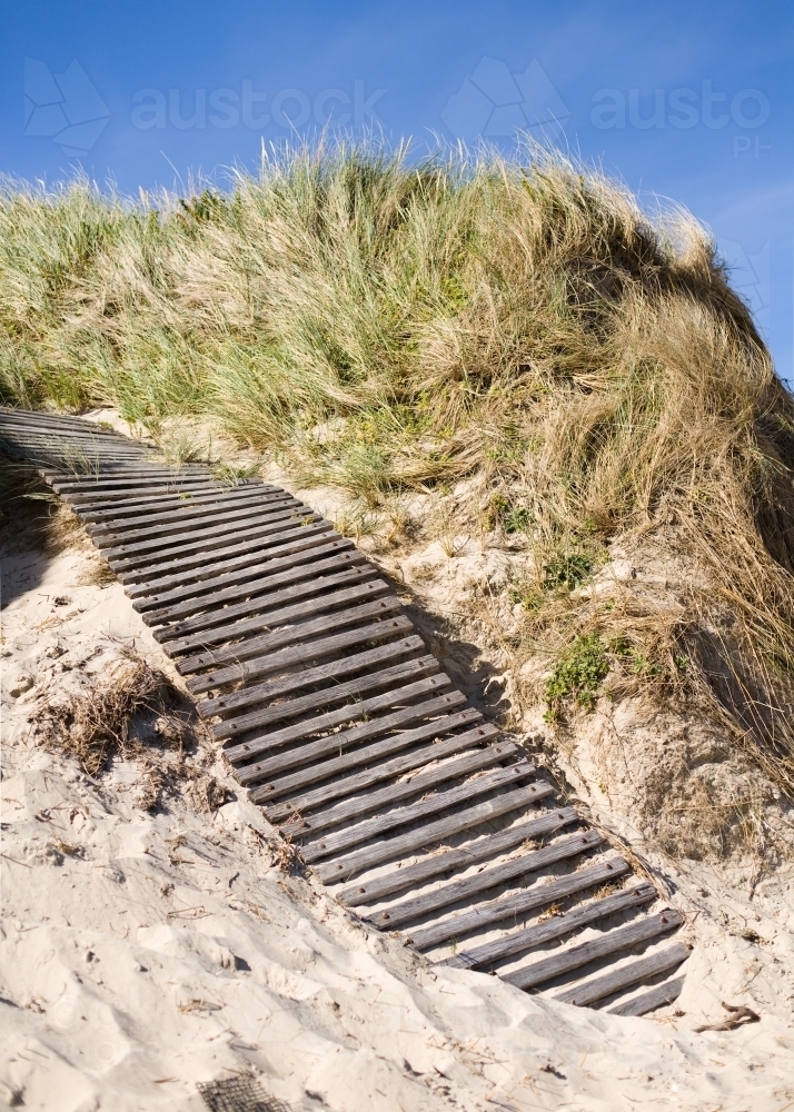 wooden boardwalk up a sand dune at a beach - Australian Stock Image