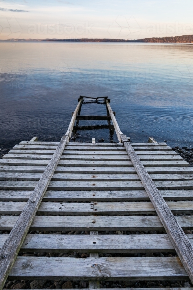 wooden boat ramp into water - Australian Stock Image