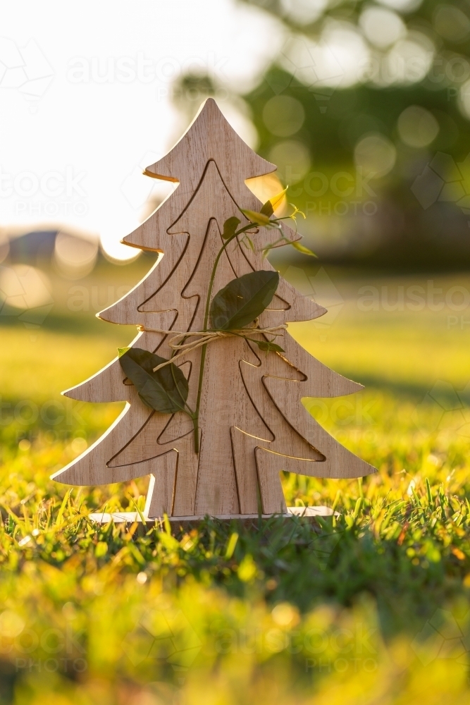 Wooden Christmas tree decoration with gum leaf twig on grass - Australian Stock Image
