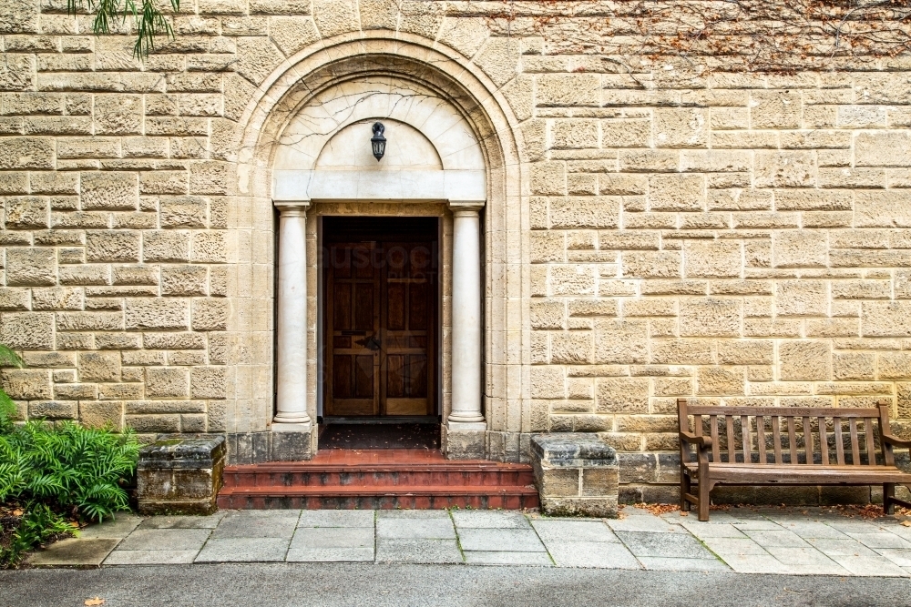 Wooden door and brick steps in old stone building. - Australian Stock Image