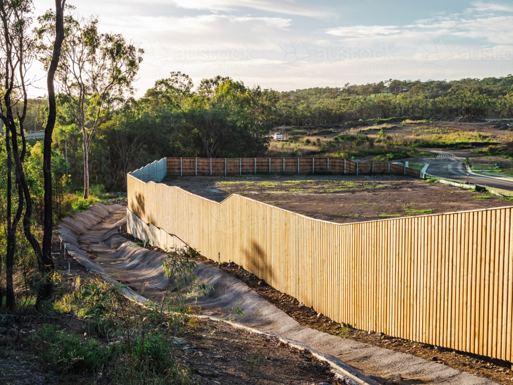 Wooden fence next to drainage and unfinished residential development - Australian Stock Image