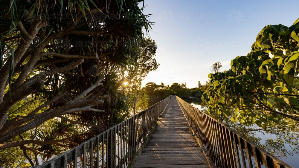 Wooden footbridge leading across Simpsons Creek at Brunswick Heads - Australian Stock Image