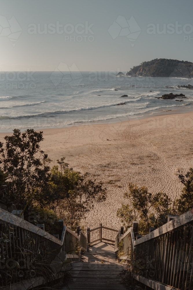 Wooden stairs leading to a secluded beach. - Australian Stock Image
