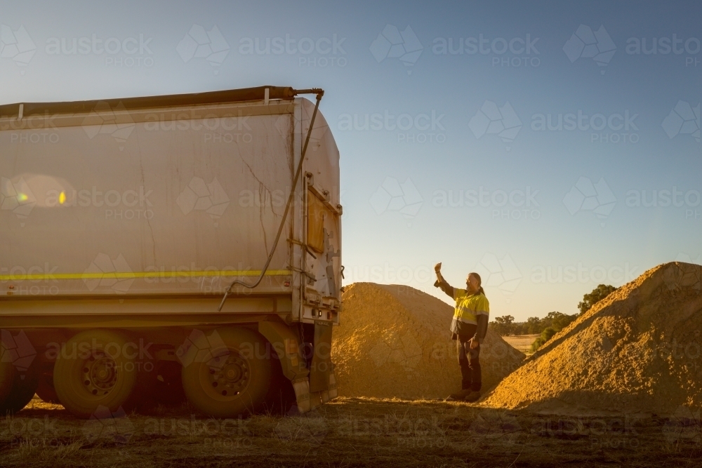 Worker directing reversing truck - Australian Stock Image