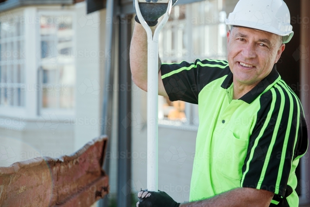 Worker using a shovel on a building site - Australian Stock Image