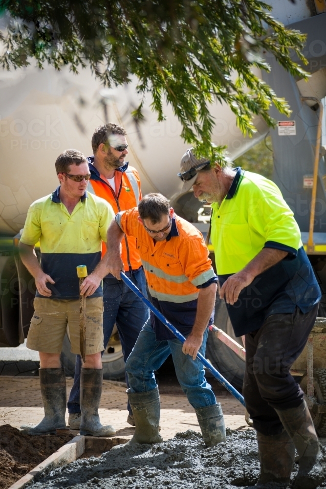 Workers in hi-vis laying concrete - Australian Stock Image
