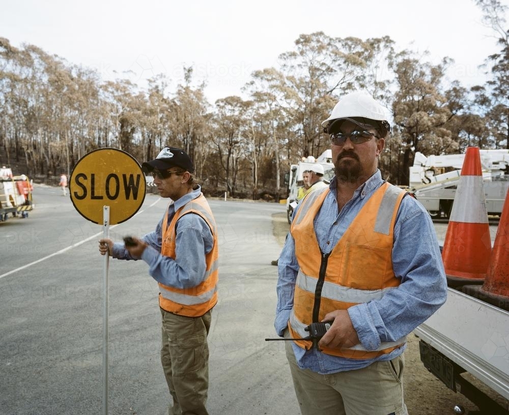 Workmen patrolling road in bushfire ravaged area - Australian Stock Image