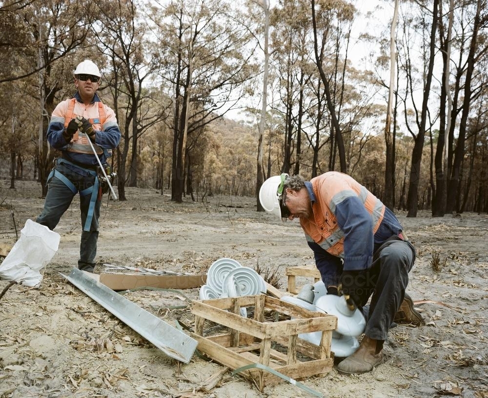 Workmen repairing power lines in bushfire ravaged landscape - Australian Stock Image