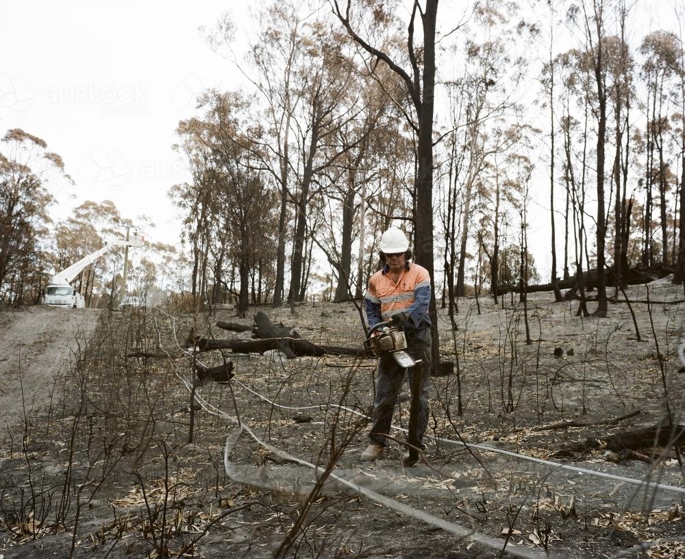 Workmen repairing power lines in bushfire ravaged landscape - Australian Stock Image