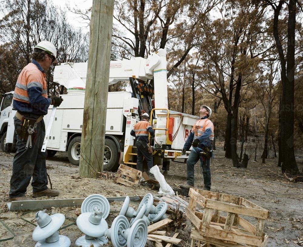 Workmen repairing power lines in bushfire ravaged landscape - Australian Stock Image