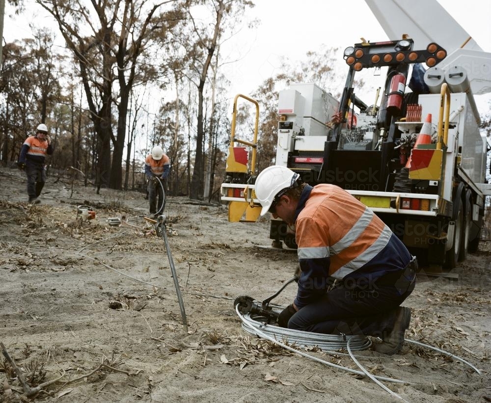 Workmen repairing power lines in bushfire ravaged landscape - Australian Stock Image
