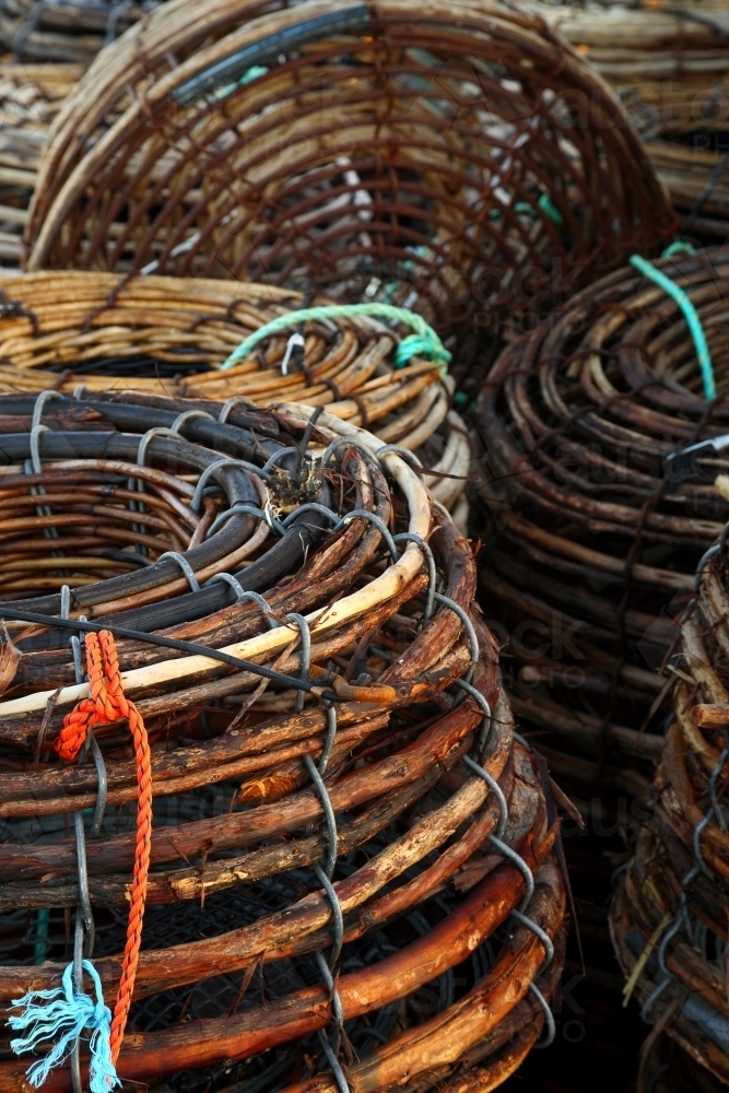 Woven cane Rock Lobster Pots stacked on the deck of a fishing boat. - Australian Stock Image