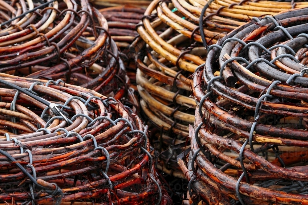 Woven cane Rock Lobster Pots stacked on the deck of a fishing boat. - Australian Stock Image